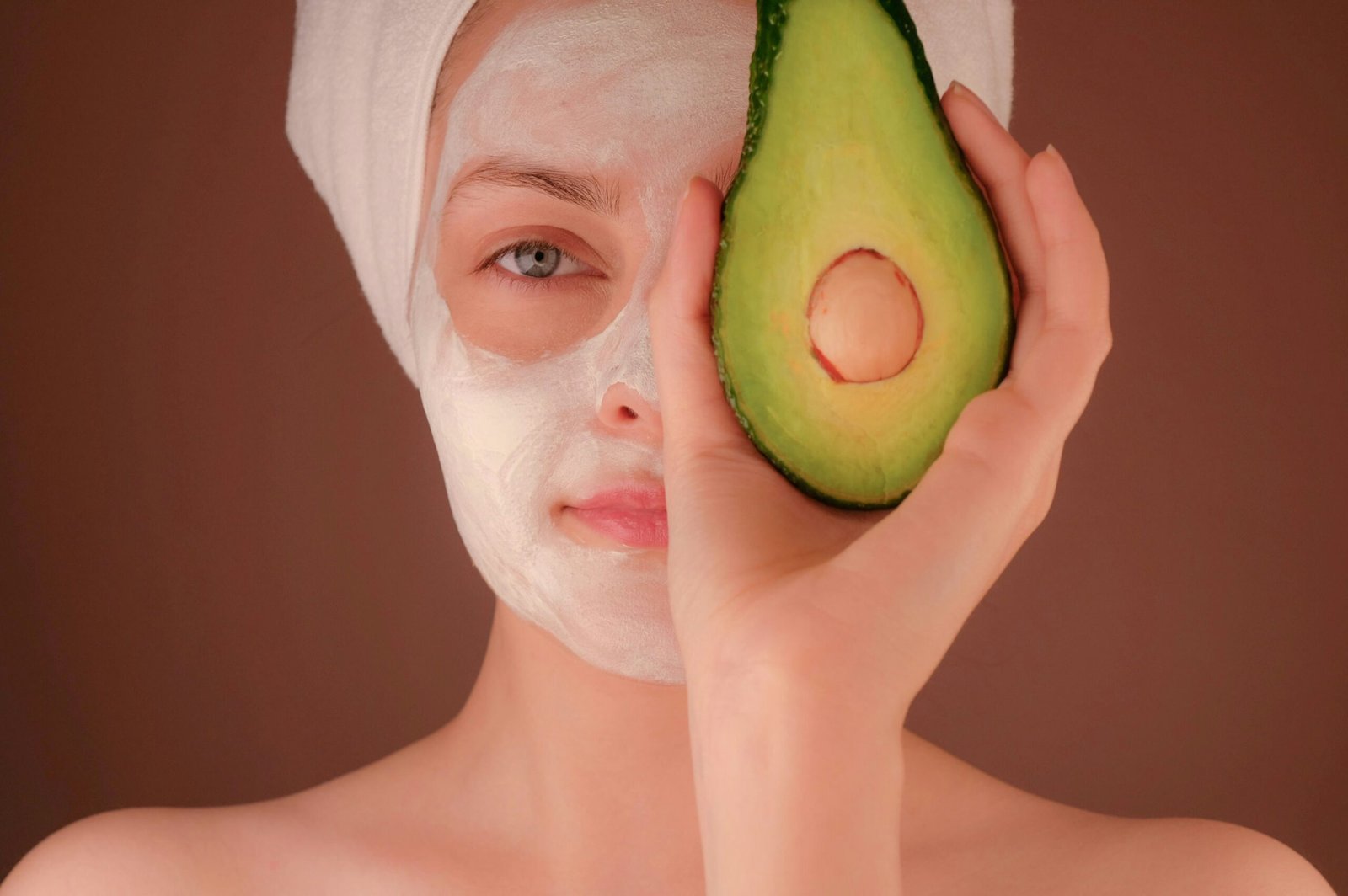 Mujer con mascarilla blanca sosteniendo fruta verde